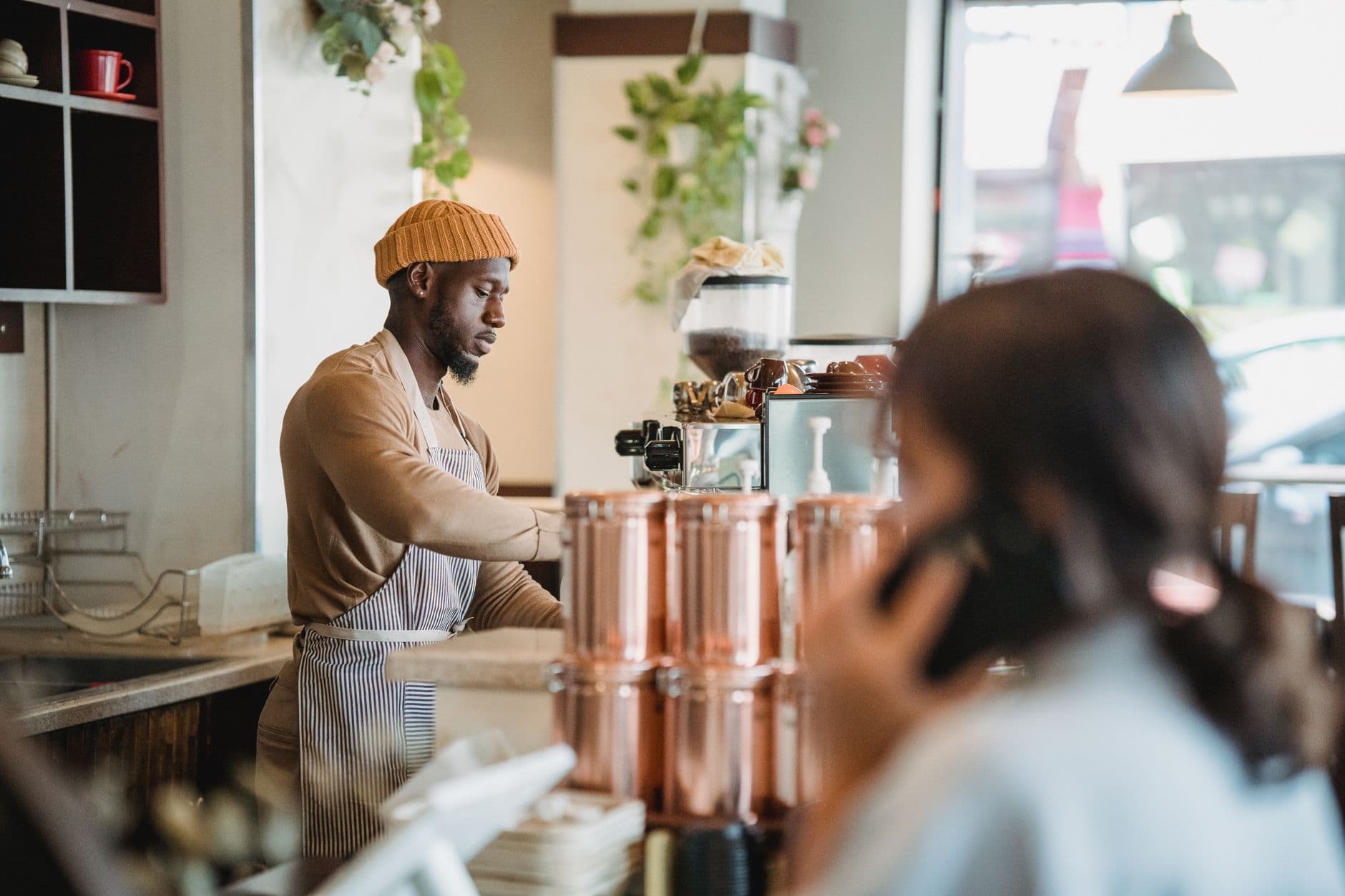 Warm café setting with barista serving customer, creating a relaxed atmosphere.