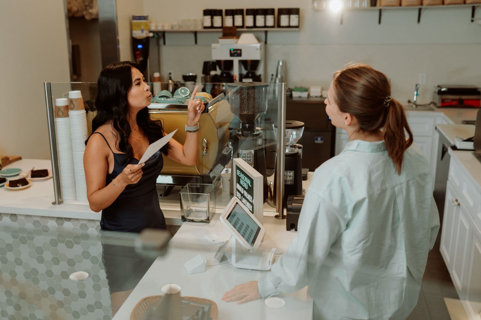 A barista and customer engaging at a modern café, conveying a warm interaction.