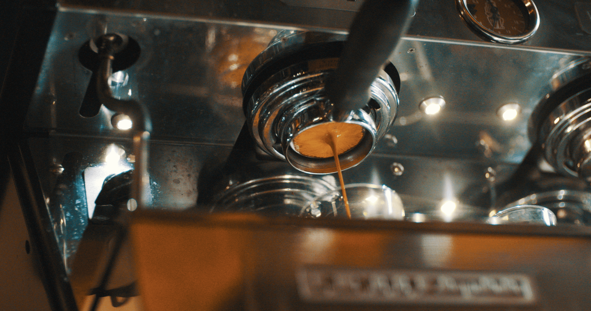 Espresso dripping from a coffee machine in a close-up, capturing the brewing process.