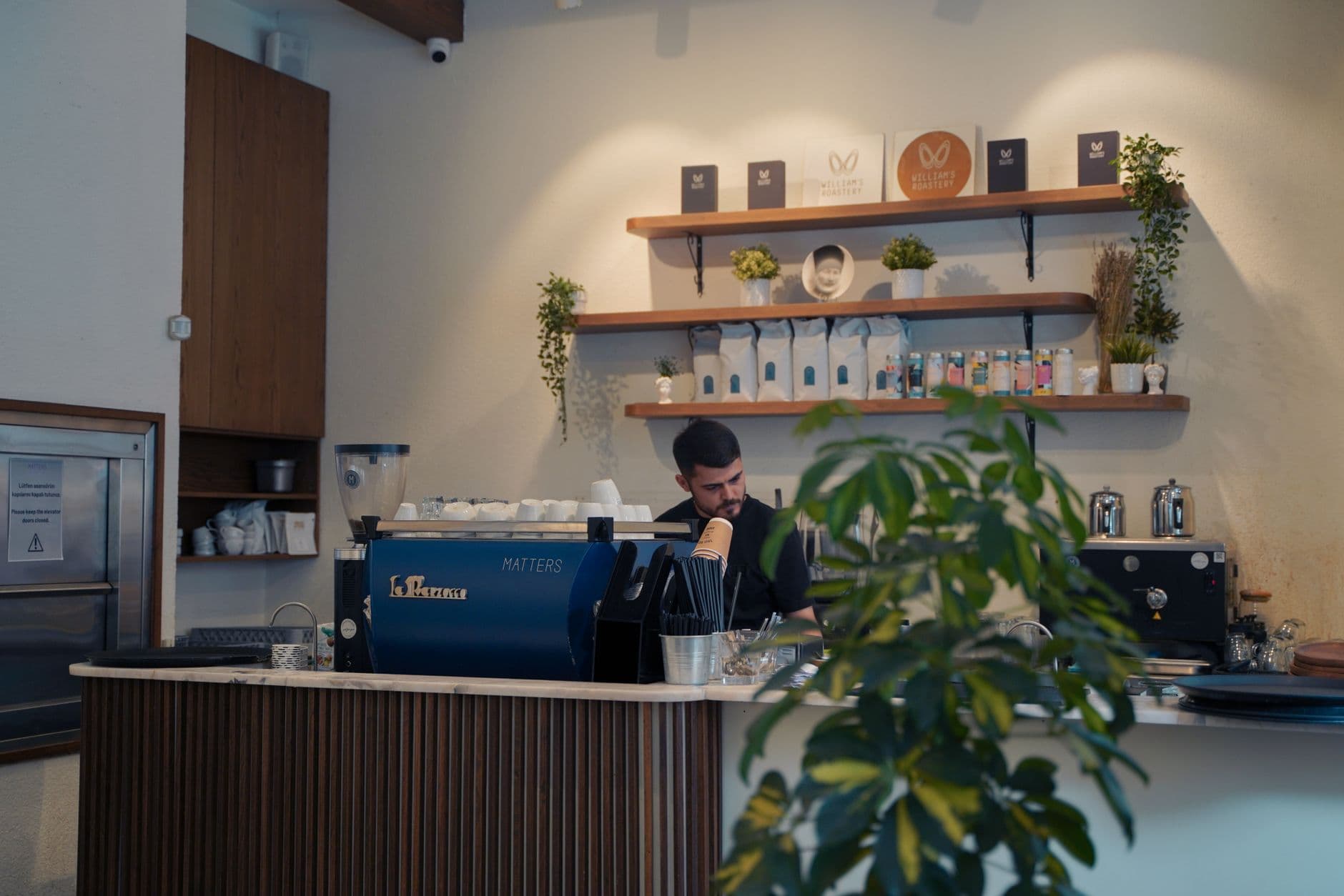Barista at work behind a modern coffee counter in an Istanbul cafe, interior view.