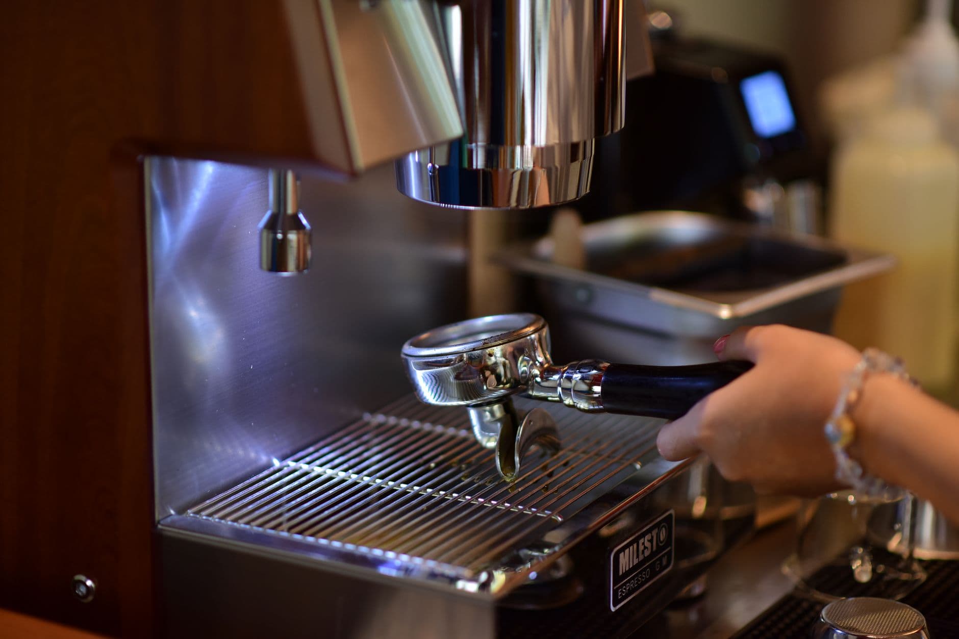 Barista handling espresso machine in a café setting, precision coffee-making at its best.