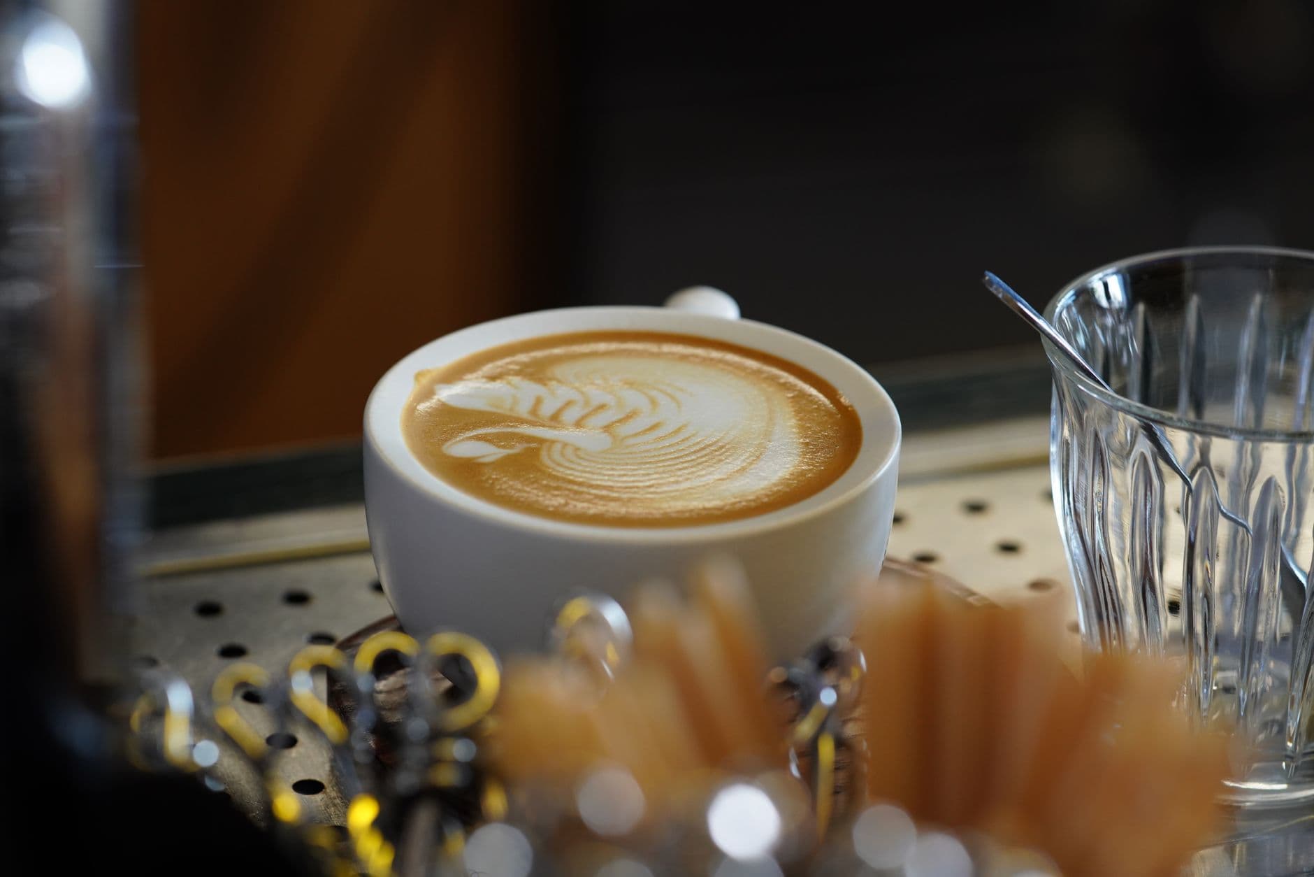 A close-up of a beautifully crafted latte with intricate latte art, served in a stylish café setting.